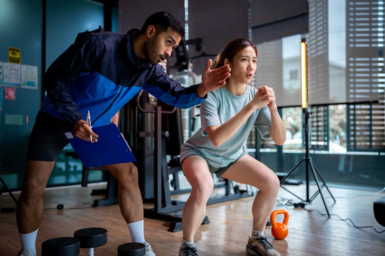 Asian man and woman working out, one is a trainer, the other is an exerciser